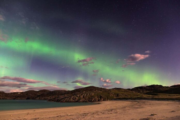 the Aurora Borealis, also known as the Northern lights, putting on a show over Achmelvich beach, Sutherland, in the Highlands of Scotland, UK.